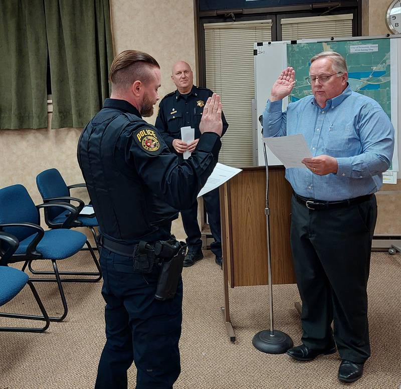 Princeton Police Sgt. Jake Foster takes an oath for his new promotion Tuesday, Feb. 20, from City Clerk Pete Nelson during the Princeton City Council meeting. Police Chief Tom Kammerer looks on.