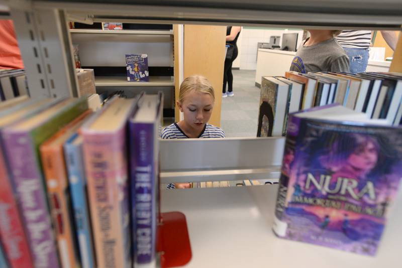 Leah Minchell of La Grange Park looks at some of the books while attending the La Grange Park Library Grand Reopening Saturday Aug. 3, 2024.