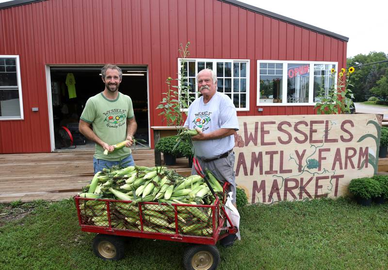 Wessels' Family Farm owners Rob Wessels (right) and his son Brandon with some of their sweet corn Tuesday, Aug. 19, 2025, at Wessels' Family Farm Market in DeKalb. They are preparing to be a big part of  this weekend’s Corn Fest.