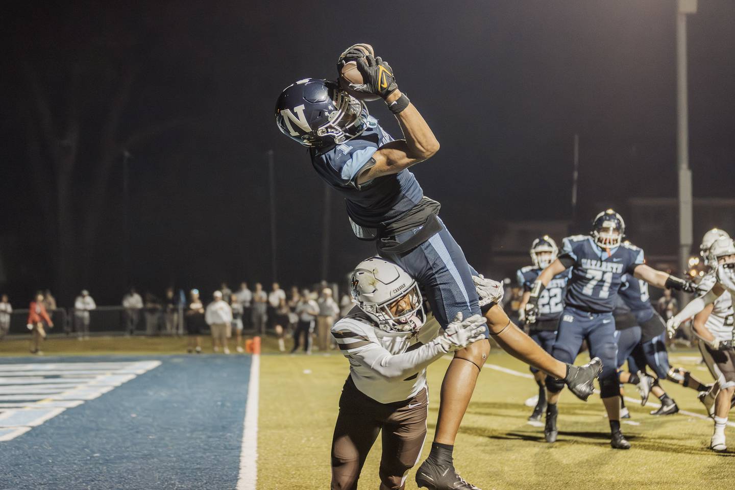 Nazareth's Trenton Walker reels in a catch over Mount Carmel's Tavares Harrington. Walker recently committed to play at Murray State.