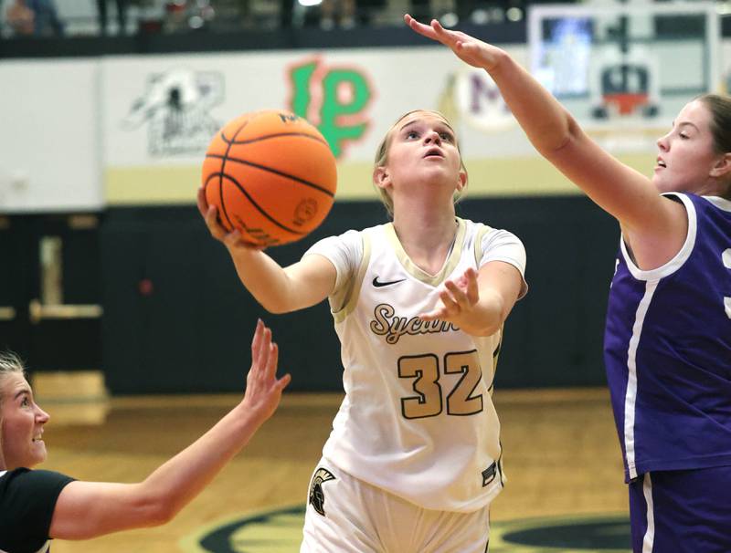 Sycamore's Quinn Carrier drives between two Rochelle defenders during their game Friday, Dec. 6, 2024, at Sycamore High School.