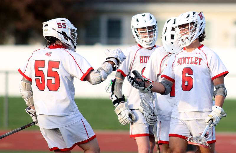 Huntley’s Justin Jacobsen, right, is greeted by teammates after scoring against Hampshire in varsity lacrosse at Huntley Thursday night.