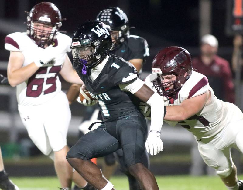 Marengo’s Connor Sacco, right, pursues ballcarrier from Woodstock North JR Fadahunsi in varsity football at Rod Poppe Field on the campus of Marengo High School in Marengo on Friday, Sept. 12, 2025.