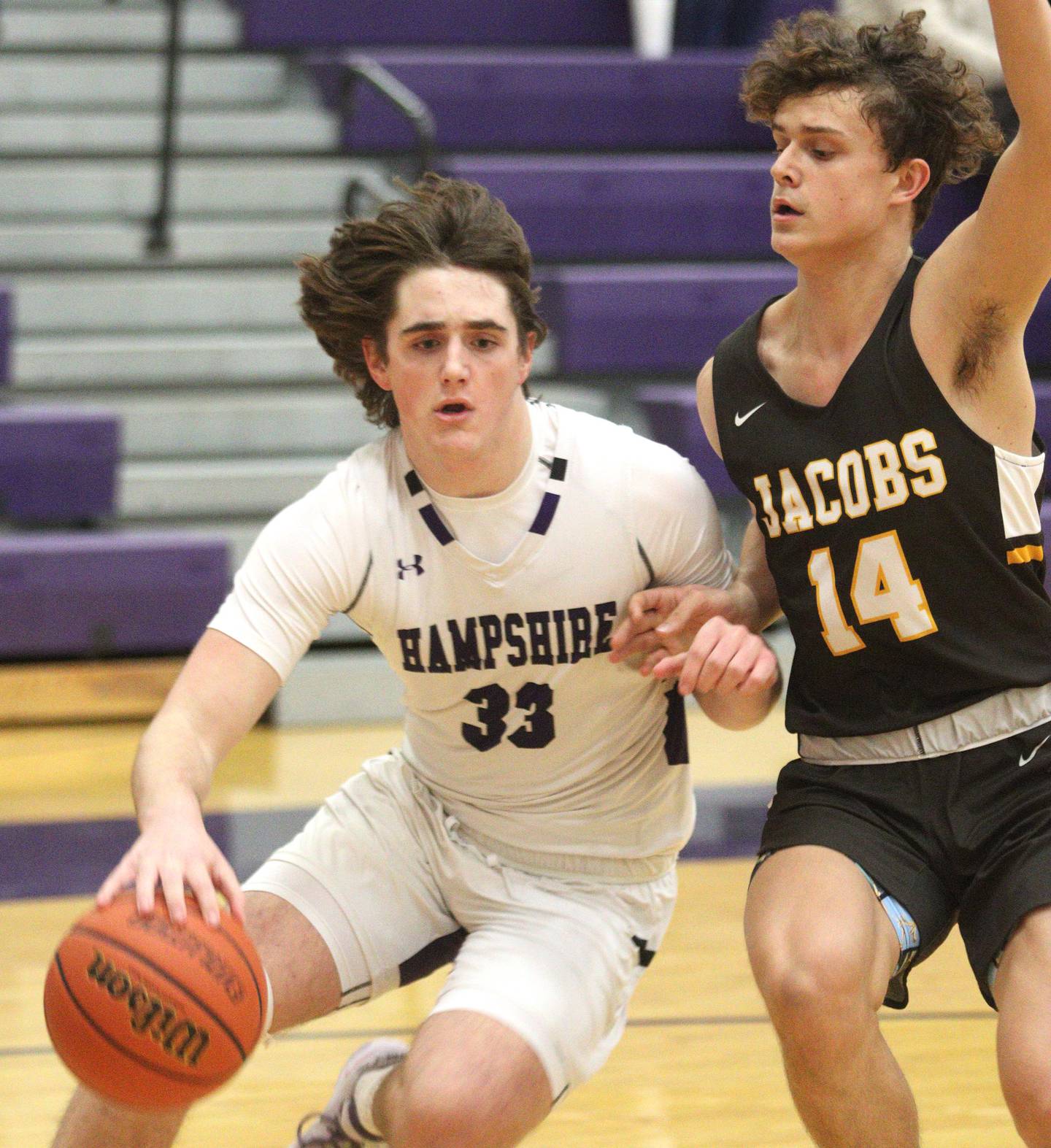 Hampshire’s Sam Ptak, left, moves the ball as Jacobs’ Brett Schlicker defends in boys basketball at Hampshire on Tuesday.