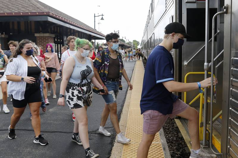 From left: Paige Linker, Melissa Ragusin, Jorge Guzman, and Derek Linker, all of McHenry, head onto the 12:10 Metra train into Chicago on Thursday, July 29, 2021 in Crystal Lake.  Dozens of 12:10 train commuters were on hand waiting for the Metra to head into Chicago for a variety of reasons, the largest one being for lollapalooza.  All four were looking forward to seeing Miley Cyrus play, with Ragusin also anticipating Orville Peck and the Linkers looking forward to the Foo Fighters as well.
