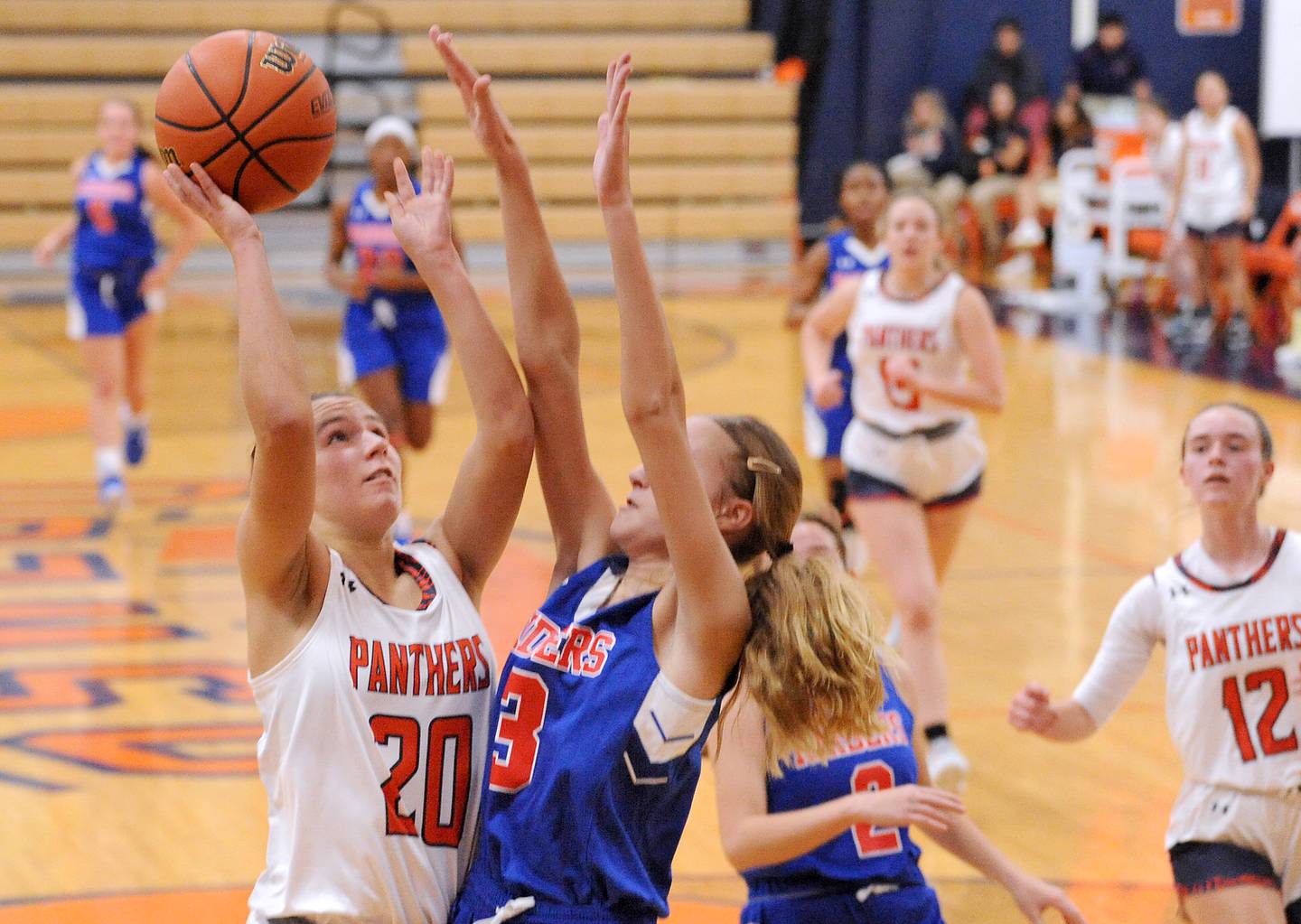 Oswego's Anna Johnson (20) shoots over Glenbard South defender Jamie Mizwicki (3) during a girls varsity basketball game at Oswego High School on Wednesday, Nov. 16, 2022.