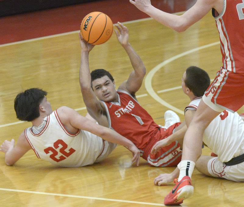 Streator’s Layzeric Moton tries to get a pass away after he and Ottawa’s Dom Parks and Alexio Fernandez dived for a loose ball in the 2nd period Saturday at Ottawa.