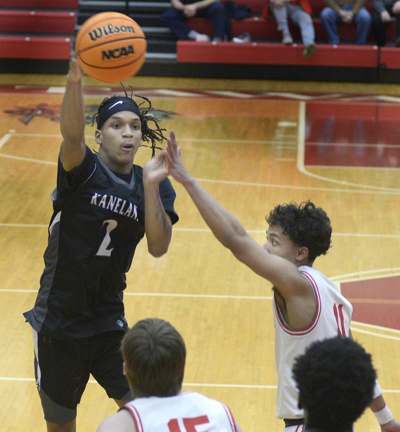 Kaneland’s Isaiah Gipson gets a pass away over the reach of Ottawa’s Hezekiah in the 2nd quarter Tuesday at Ottawa.
