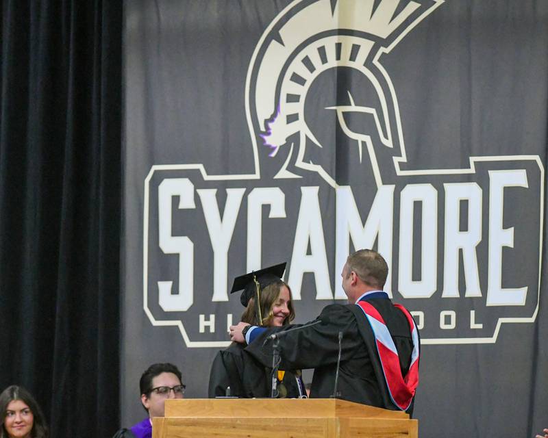 Sycamore High School principal Brian Swanson gives Salutatorian Anna Berry on Sunday, May 25, 2025, during the Class of 2025 Commencement ceremony at the high school.