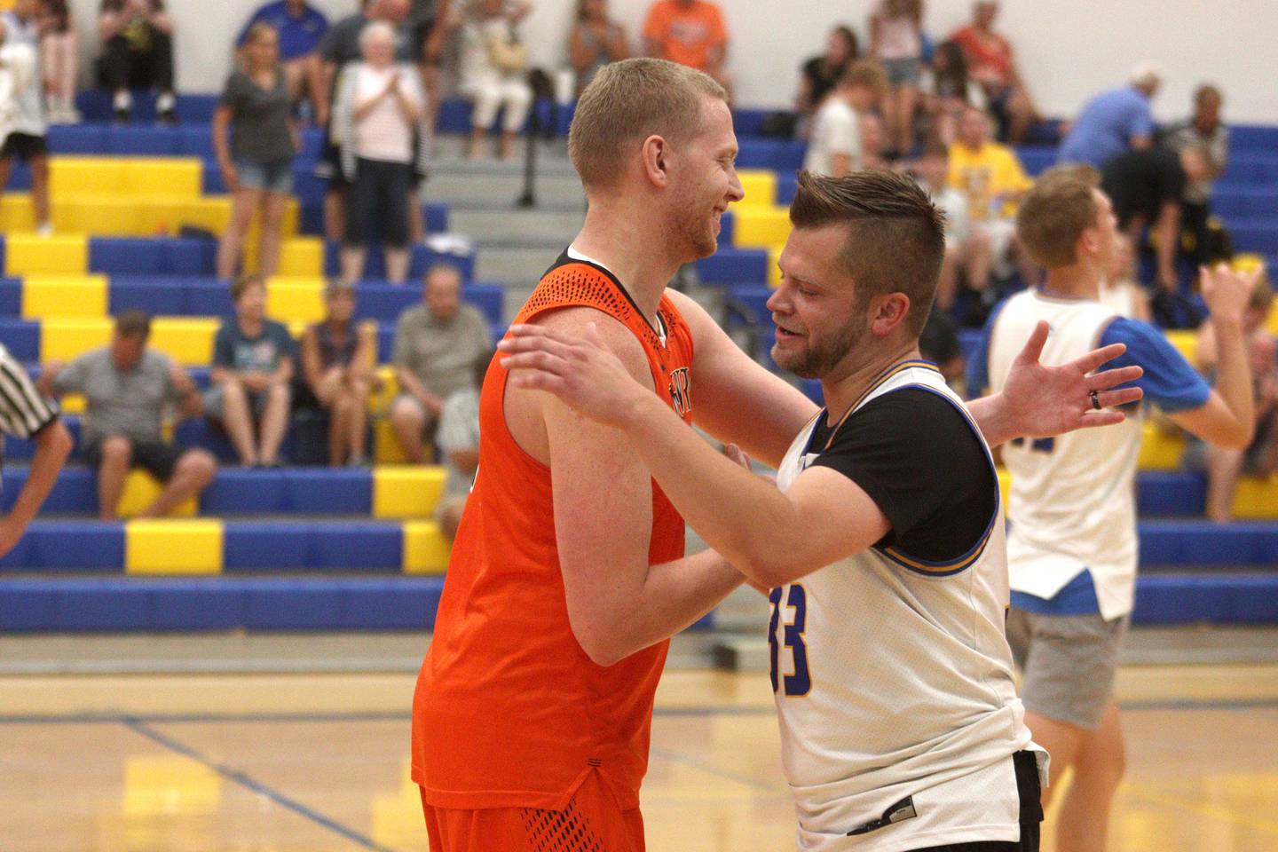 McHenry’s Brian Madson, left, and Johnsburg’s Mike Dixon greet each other after an alumni basketball game at Johnsburg High School Saturday evening to benefit the family of Jackson Werderitch, a 10-year-old who was struck by a car.