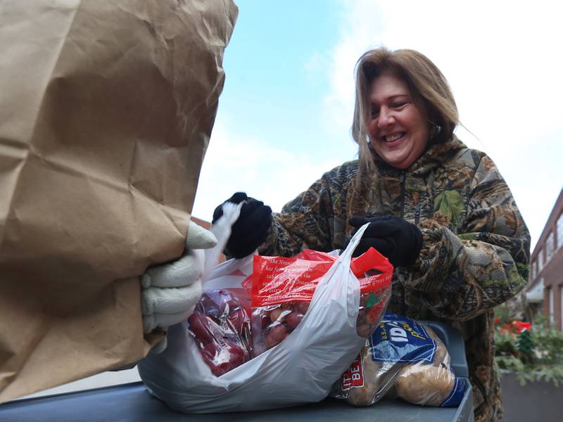 Mary Jo Credi executive director of the Illinois Valley Food Pantry, carries food to a client during the Christmas distribution on Wednesday, Dec. 18, 2024 at the Illinois Valley Food Pantry in La Salle.