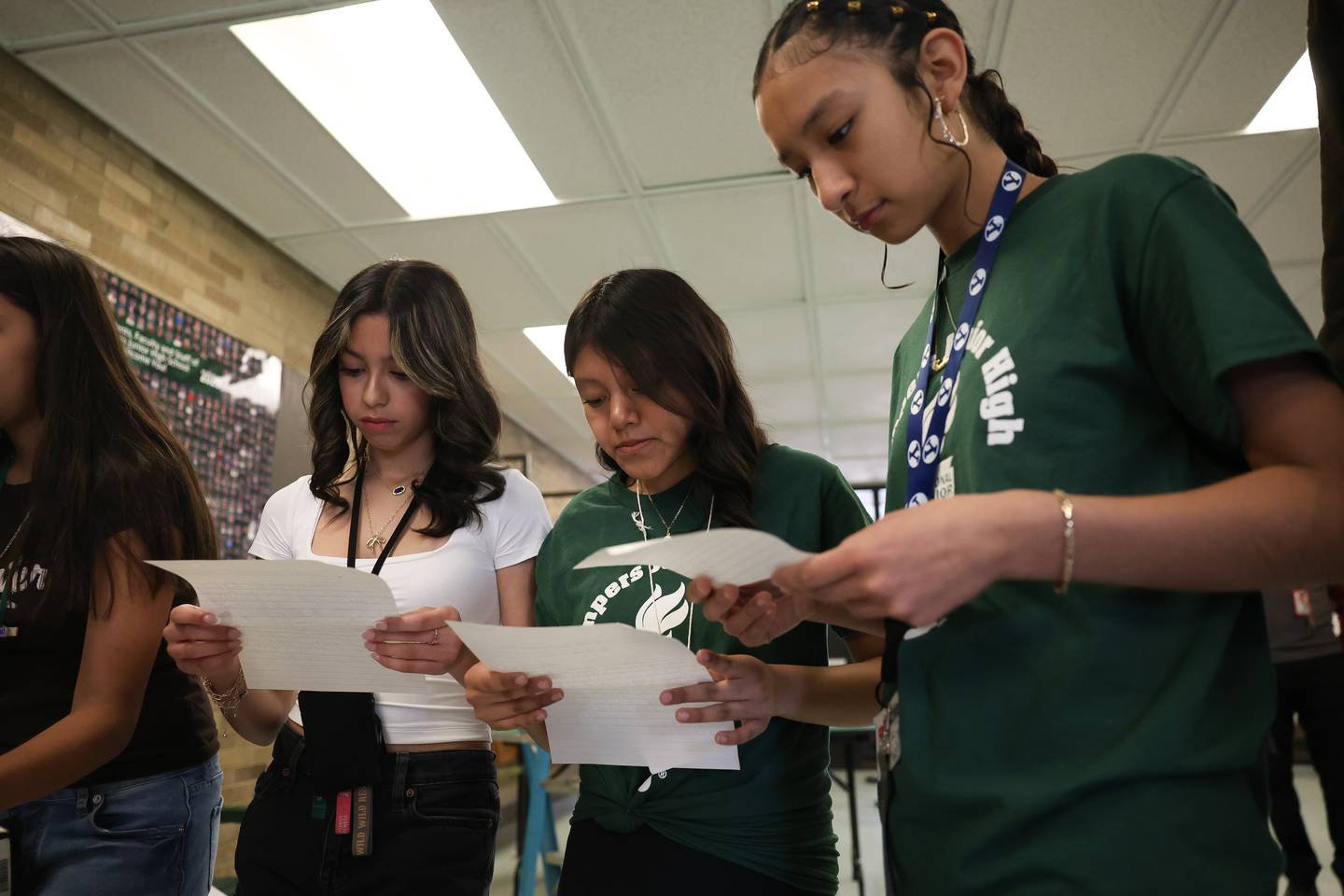 Grompers Junior High School students Isabella Campos, left, Jocelyn Lopez and Isabella Salgado read letters found in a time capsule on Wednesday, May 1, 2026 in Joliet. In 1969 students placed items in a time capsule and sealed it inside a wall when an extension was built at Grompers Junior High School.