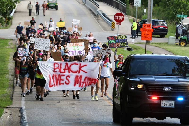 About a hundred demonstrators march up Winn Road to Thelen Park during a peaceful Black Lives Matter and LGBTQ+ Pride rally on Friday, June 12, 2020 in Spring Grove. Demonstrators met at Thelen Park for a few speakers, then marched approximately two miles to Horse Fair Park for additional speakers before making a return march to Thelen Park.