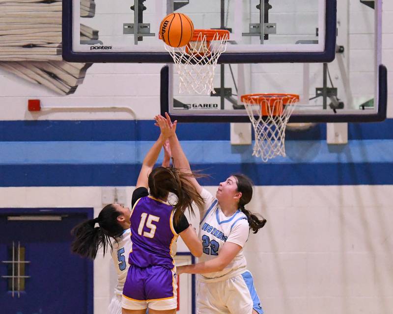 Downers Grove South's Katelyn Konieczka, right and Downers Grove South's Kayla Meyer (5) tries to block the basket of Downers Grove North's Adysen Fanta (15) during the game on Saturday Dec. 21, 2024, held at Downers Grove South High School.