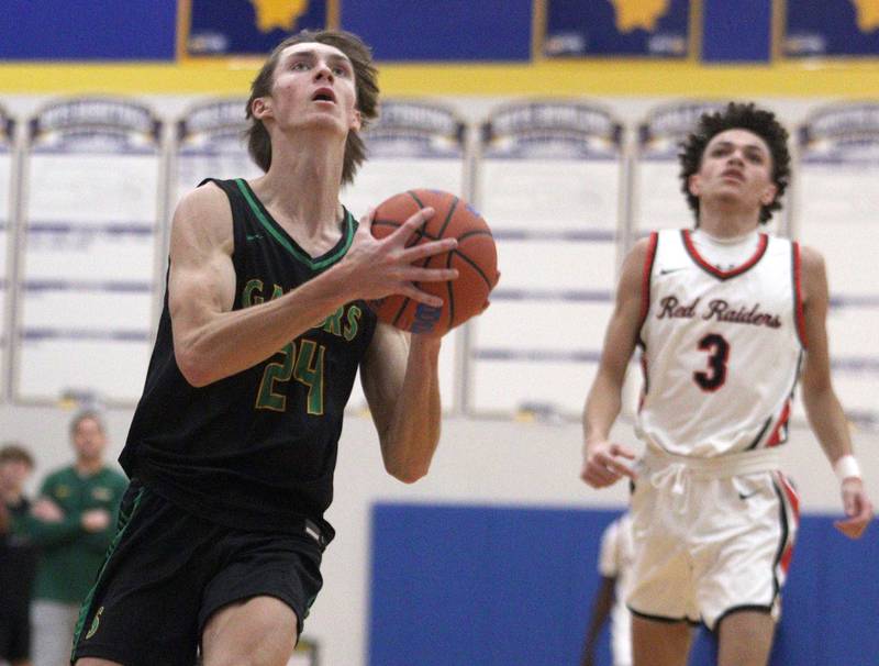 Crystal Lake South’s James Carlson takes the ball to the hoop in varsity basketball tournament title game action at Johnsburg Friday.