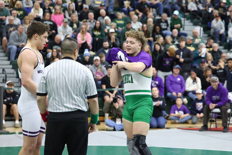 After losing to Wilmington's Logan Van Duyne, left, in the 190-pound championship match, Seneca's Landen Venecia puts on a shirt honoring the late Wilmington wrestling coach Nick Dziuban before shaking hands during the IHSA Class 1A Coal City Sectional on Saturday, Feb. 14, 2026.