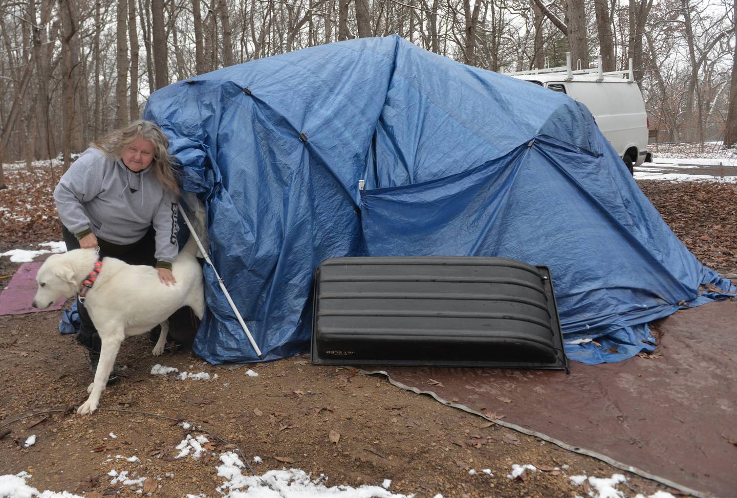 Sarah Wright and her dog, Luna, exit their tent at Lowden State Park on Sunday, Jan. 7, 2024. Wright has been living in state parks for several months as she searches for a rental property that will accept pets. An Oregon man gave her a van and camping trailer last. month and repairs have started on the 8'x13' trailer, Wright said.