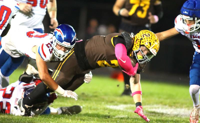 Jacobs’ Caden DuMelle lunges for yardage as Dundee-Crown’s Max Backaus, left, moves in for a tackle in varsity football  at Jacobs High School in Algonquin on Friday, Oct. 10, 2025.