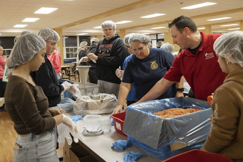 Fulton students are instructed on how to measure and fill the meal bags Wednesday, Nov. 6, 2024.