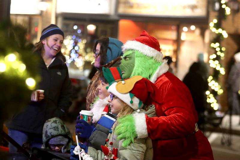 The Grinch poses with youngsters during the Festival of Lights Holiday Parade in downtown Crystal Lake on Friday, Nov. 29, 2024.