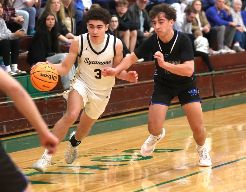 Sycamore's Marcus Johnson goes by Woodstock's Marc Thomas Friday, Feb. 27, 2026, during their IHSA Class 3A boys basketball regional championship game at Boylan Catholic High School in Rockford.