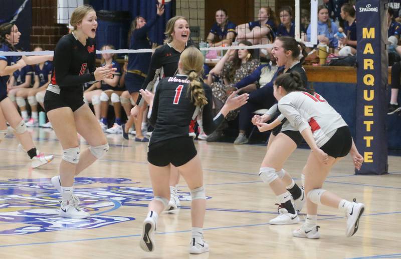 Members of the Woodland volleyball team react after scoring a point against Marquette on Thursday, Oct. 19, 2023 at Bader Gym.