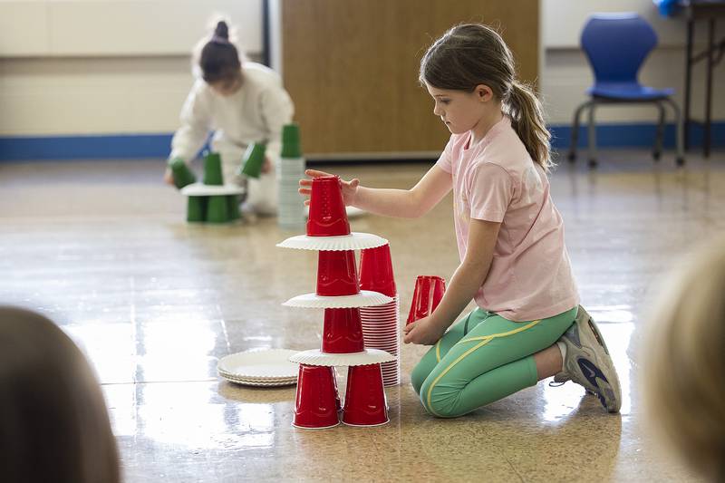 Maggie Shaddick, second grader at St. Anne’s School, stacks cups and paper plates during a Minute To Win It game Tuesday, Jan. 28, 2025, at the school. In celebration of Catholic Schools Week, students are being treated to a week of fun and service.