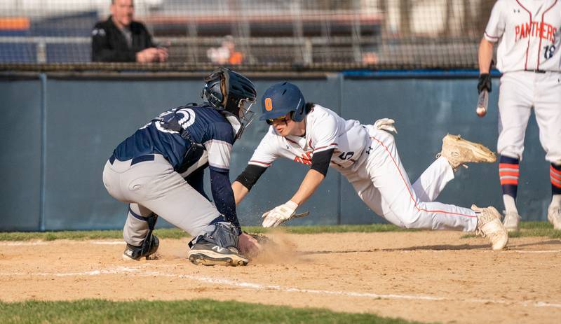 Oswego’s Ethan Valles (5) makes a head first slide to beat the throw to home against Plainfield South during a baseball game at Oswego High School on Monday, April 11, 2022.