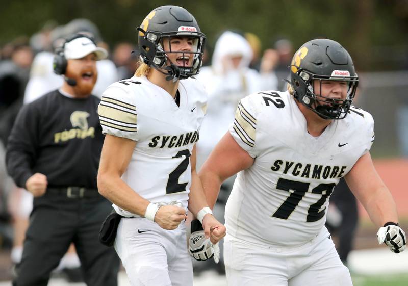 Sycamore's Elijah Meier (left) and Lincoln Cooley celebrate a defensive stop on fourth down during their Class 5A second round playoff game against Carmel Saturday, Nov. 5, 2022, at Carmel Catholic High School in Mundelein.