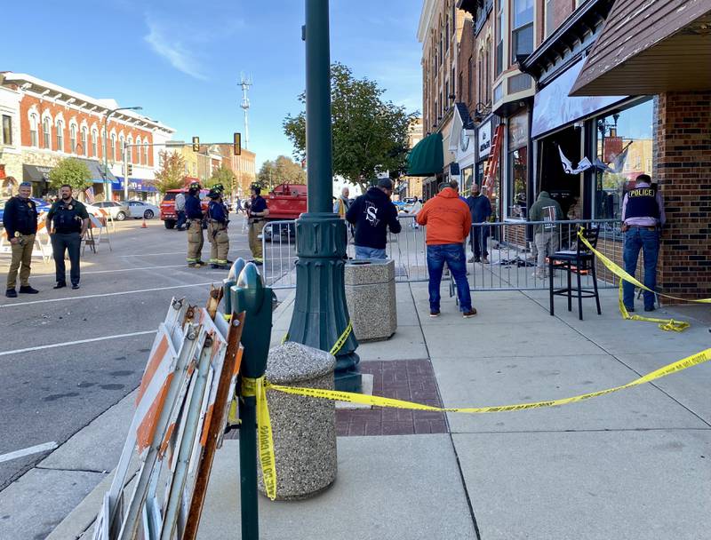 Authorities build a barricade and walkway to keep pedestrians safe and away from debris on Friday, Oct. 24, 2025, after a building in the 300 block of West State Street in downtown Sycamore was damaged when a white SUV crashed into the front of Atlas Roots Collective, 330 W. State St., police said.