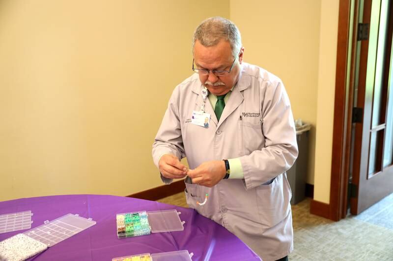 Luis Saltigerald, assistant chaplain at Northwestern Medicine Central DuPage Hospital in Winfield, makes a friendship bracelet as part of the hospital’s National Nurses Week activities on Monday, May 6, 2024.