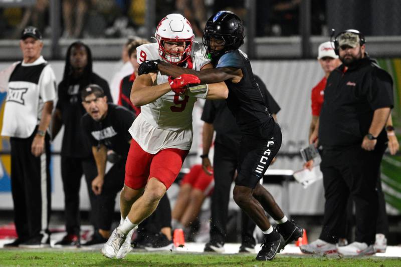 Houston tight end Tanner Koziol (9) is tackled by Central Florida defensive back Antione Jackson (7) after catching a pass during the second half of a 2025 NCAA college football game in Orlando, Fla. (AP Photo/Phelan M. Ebenhack)