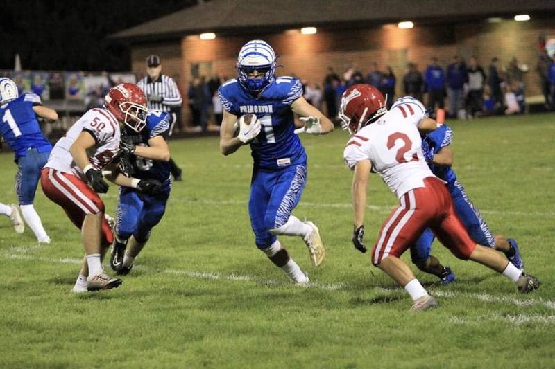 Princeton junior Noah LaPorte splits Hall defenders Leo Lopez (50) and Miguel Reveles (2) Friday night at Bryant Field. The Tigers won 54-0.