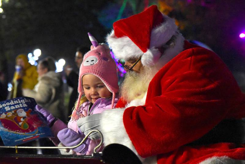 Four-year-old Mia Flaharty sits on Santa's lap during Christmas in the Village. The Mt. Morris Library donated books for Santa to hand out to kids during the event on Saturday, Dec. 2, 2023.