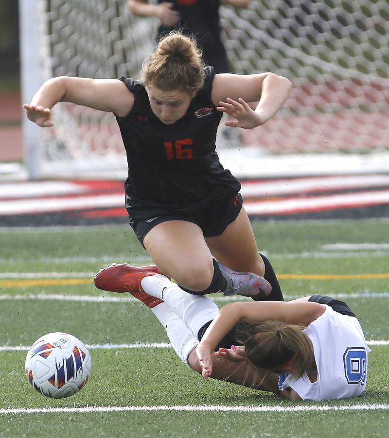 Libertyville’s Shea Krakowski tries to keep her balance as Lincoln-Way East's Elizabeth Burfeind hits the turf during the IHSA Class 3A state third-place match at North Central College in Naperville on Saturday, June 3, 2023.