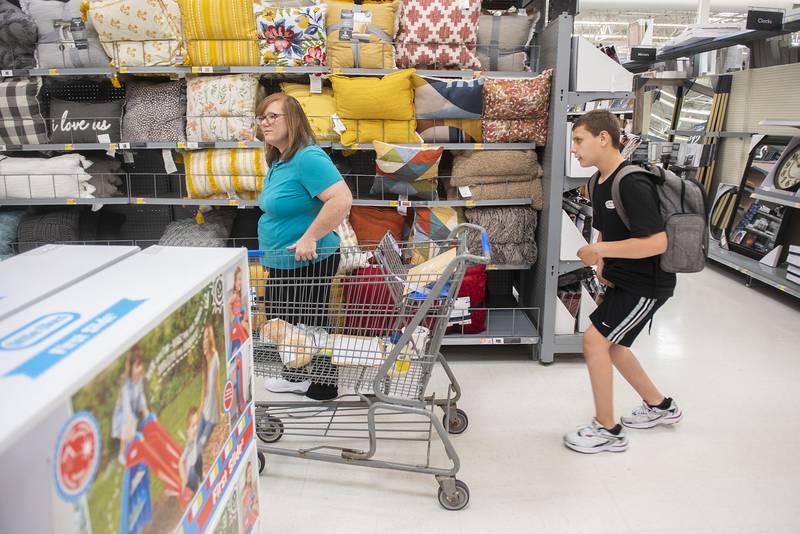 Para-professional Peggy Sturgeon and Troy Kendall make their way to the check out after completing their shopping.