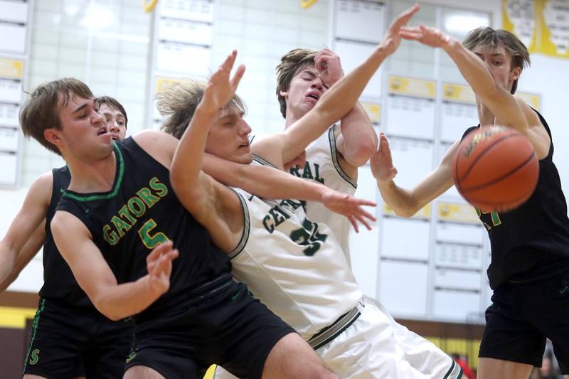 Crystal Lake South’s Brady Schroeder, left, and James Carlson, right, battles Grayslake Central’s Jake Gibson, center left, and Jake Kruse, center right, for the ball during Hinkle Holiday Classic Basketball Tournament title game action at Jacobs High School Friday.