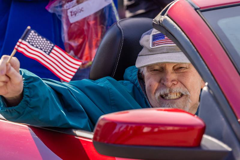 A Veteran in the parade waves to parade attendees as the rides by them at the Utica Veterans Parade and Airshow on November 2, 2025 in Utica.