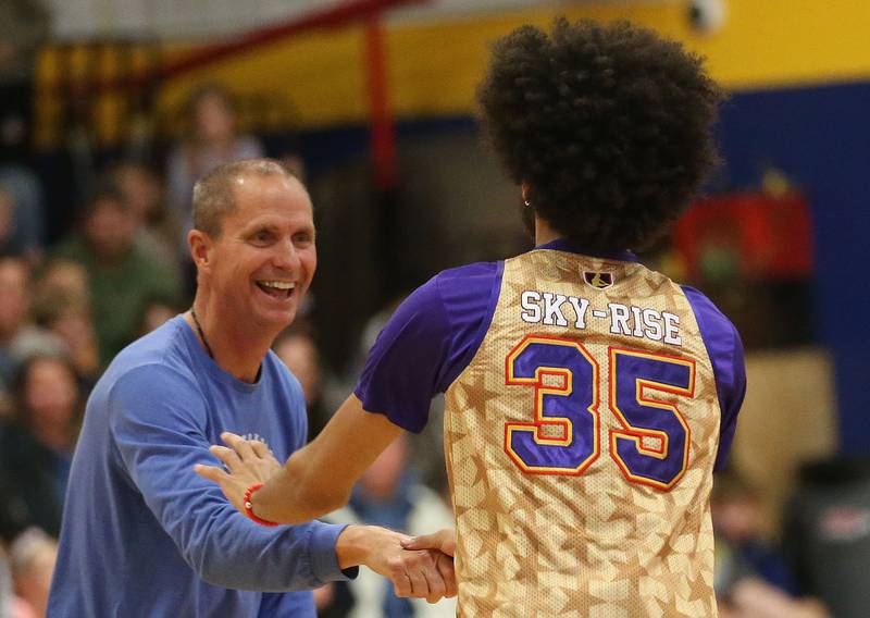 Princeton High School head freshman basketball coach Tim Smith, hi-fives Harlem Wizards player Tyler Cronk (Sky-Rise) during the Harlem Wizards event on Tuesday, Oct. 28, 2025 in Pannebaker Gymnasium at Logan Jr. High School in Princeton.