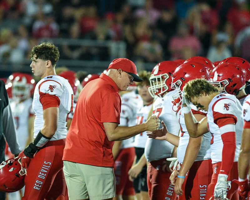 Hinsdale Central’s coach Aaron Myall gives all the players a handshake before the start of the game on Friday Sept. 12, 2025, while traveling to take on Downers Grove North.