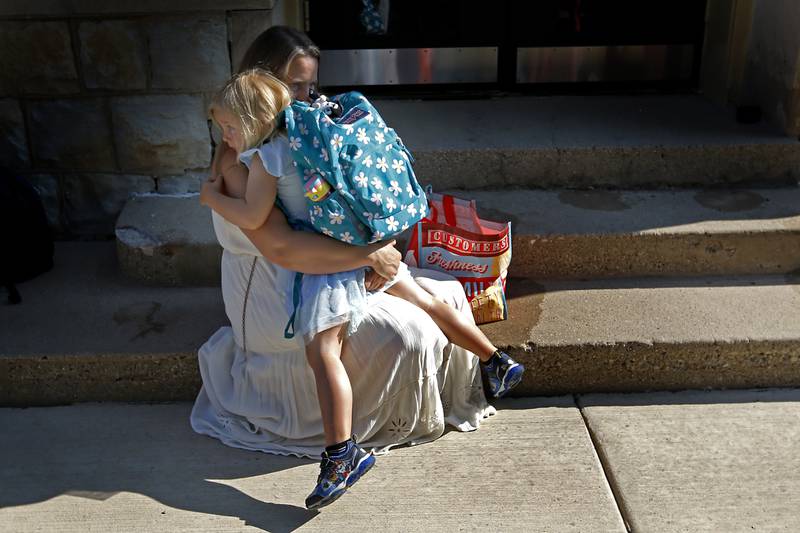 Heather Detloff hugs her daughter, Eve, 5, on the steps of McHenry's Landmark Elementary School  before the start of the first day of school on Wednesday, July 17, 2024.