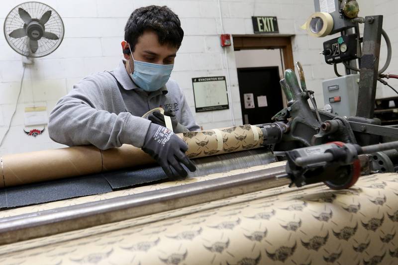 Machine operator Justin Vazquez spools grip tape onto tubes at Jessup Manufacturing on Thursday, March 18, 2021, in McHenry.  The company, which makes grip tape for skateboards, is in the running for a competition looking for the "coolest thing made in Illinois."