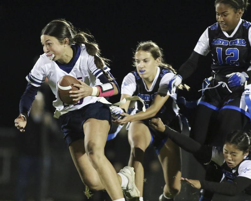 Oswego East's Danielle Stone (26) runs away from the defense during Oswego East Regional Final flag football game between St. Charles North at Oswego East Thursday, Oct 9, 2025 in Oswego.