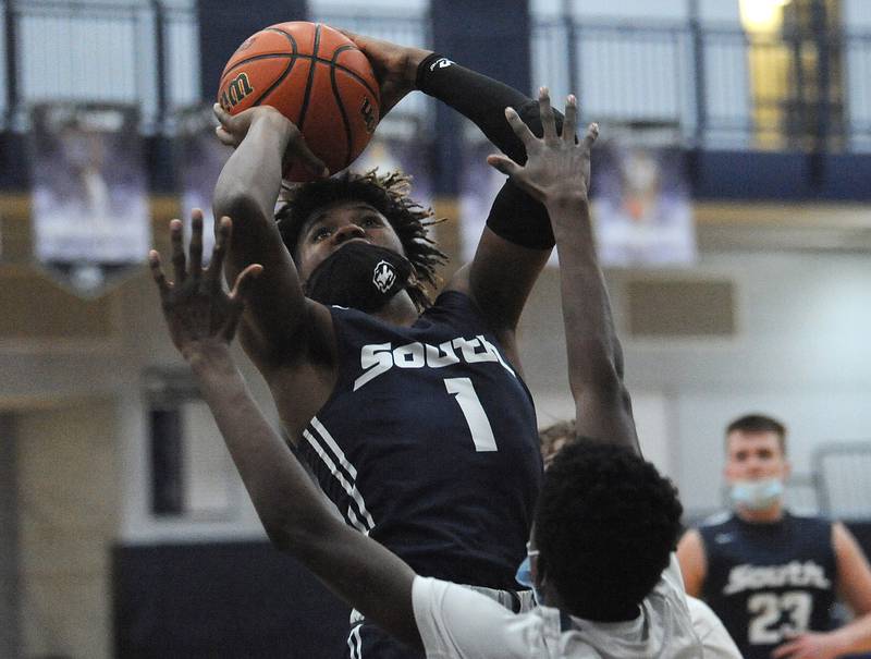 Plainfield South's Amarion Molette (1) takes and makes a jump shot over Oswego East's Darren Oregon (21) during the Suburban Prairie Conference Tournament varsity boys semifinal basketball game at Oswego East High School on March 12.