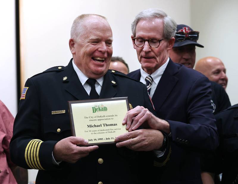 Retiring DeKalb Fire Chief Mike Thomas receives a plaque from city manager Bill Nicklas Monday, June 23, 2025, thanking him for his 30 years of service during the DeKalb City Council meeting at the DeKalb Public Library.