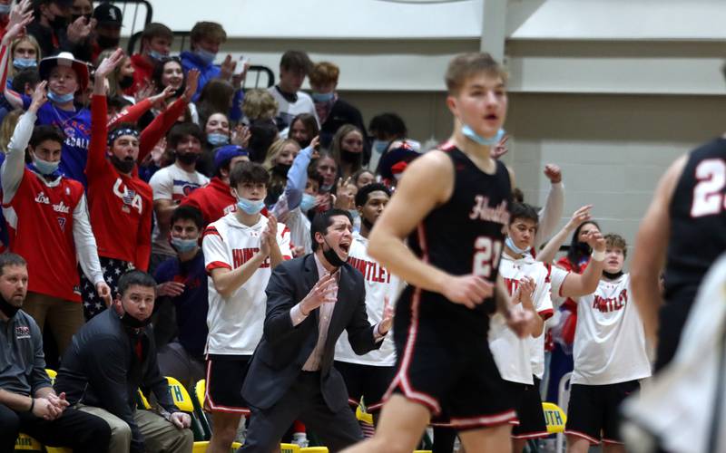 Huntley’s players, coaches, and fans celebrate an Aiden Wieczorek three-point basket in boys varsity basketball at Crystal Lake South Friday night.