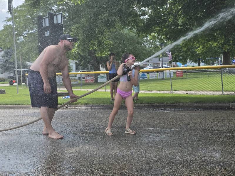 Rylie Konczak directs her hose Saturday, Aug. 3, 2024 during the Granville Days water fights at Hopkins Park.