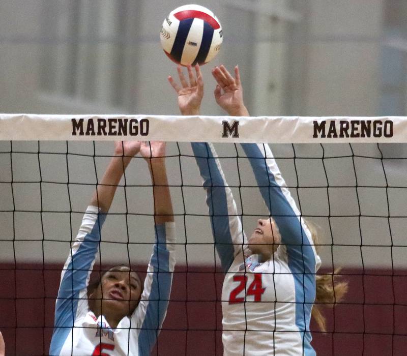 Marengo’s Marian Central’s Kalia Parris, left, and Caroline Conner block in IHSA Class 2A Regional volleyball action on Monday, Oct. 28, 2024, at  Marengo High School  in Marengo.