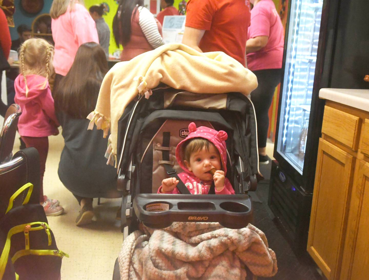 Ayla Fraley, 10 months, of Oregon, waits patiently in her stroller as her mom orders at Hector's Cocina in Conover Square during Oregon's Candlelight Walk on Nov. 26.