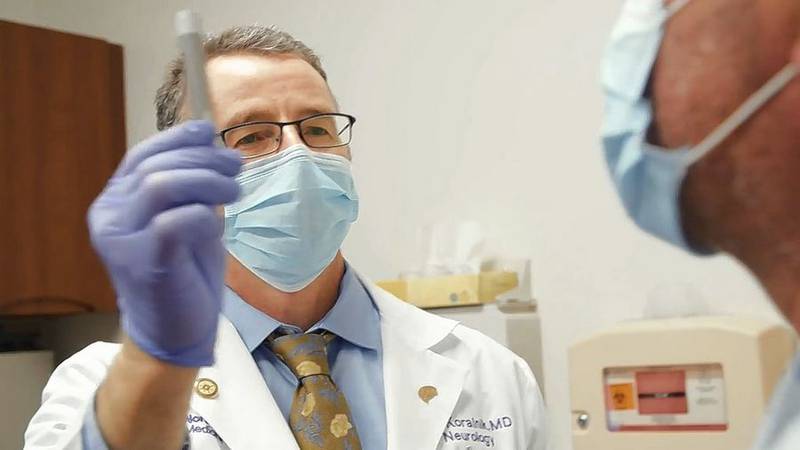 Dr. Igor Koralnik, chief of neuro-infectious diseases at Northwestern Medicine, examines a long-haul COVID-19 patient at a recent clinic visit.